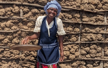 A Mary's Meals cook smiling in front of the camera.