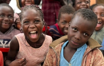 Children pictured smiling and looking into the camera.