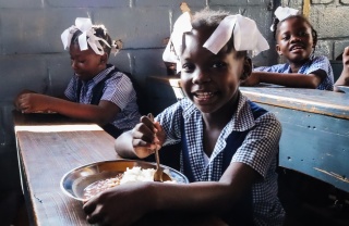 Girls eating Mary's Meals in Haiti