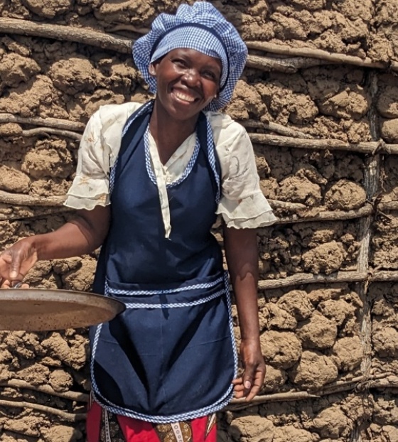 A Mary's Meals cook smiling in front of the camera.